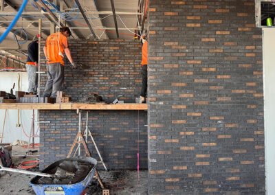 Detailed dark brick feature wall being built inside a modern property