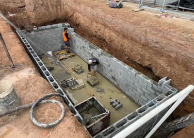 Reinforced block wall installation within a prepared building foundation